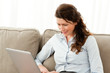 Happy businesswoman working on her laptop at home
