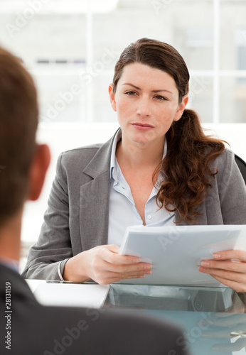 Photo: Serious businesswoman questionning a man during a meeting Serious businesswoman questionning a man during a meeting