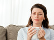 Thoughtful woman drinking coffee on the sofa Thoughtful woman drinking coffee on the sofa