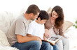 Happy family looking at a photo album together on the sofa