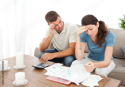 Photo: Worried couple doing their accounts in the living room Worried couple doing their accounts in the living room