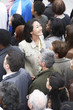 Foto: Woman facing the other way to rest of crowd, elevated view Woman facing the other way to rest of crowd, elevated view