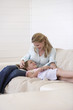 Daughter lying on mothers lap on couch