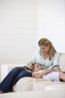 Daughter lying on mothers lap on couch
