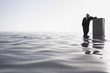 Business man leaning on filing cabinet standing in sea