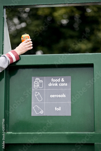 Photo: A teenage girl recycling a drink can A teenage girl recycling a drink can