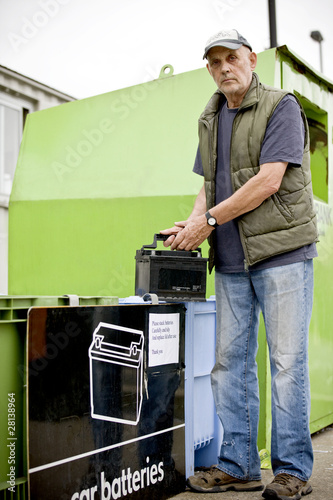 Photo: A senior man recycling a car battery A senior man recycling a car battery