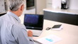 Closeup of happy senior man working on laptop