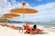 girl on the beach under straw umbrella