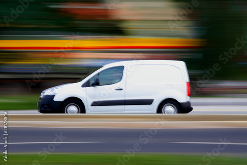 Photo: Speedy white minivan is going on road, panning and blur Speedy white minivan is going on road, panning and blur