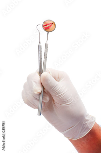 Photo: A dentists hands holding dental tools A dentists hands holding dental tools