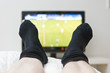 watching a game on tv in dark socks with a hole watching a game on tv in dark socks with a hole