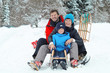 Foto: Familie beim Schlitten fahren Familie beim Schlitten fahren