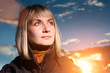 Beautiful blond girl over blue sky at sunset