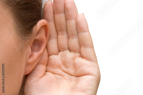 Photo: Girl listening with her hand on an ear Girl listening with her hand on an ear