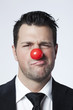 jeune homme d'affaires nez de clown doute
