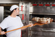 bäcker holt frisches brot aus dem ofen