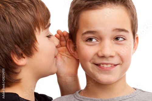 Foto: Zwei Jungen flüstern sich News und Geheimnisse ins Ohr Zwei Jungen flüstern sich News und Geheimnisse ins Ohr