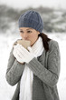 Woman drinking hot drink in the snow