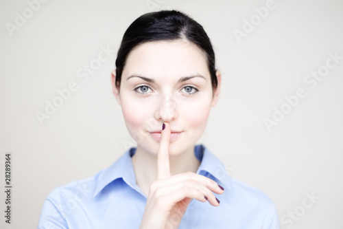Foto: junge geschäfts frau legt geheimnisvoll finger auf lippen junge geschäfts frau legt geheimnisvoll finger auf lippen