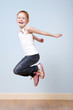 Foto: Trendy red-haired girl jumping indoors Trendy red-haired girl jumping indoors