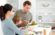 Dad serving salad to his family for lunch Dad serving salad to his family for lunch