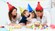 Happy family having fn while eating birthday cake