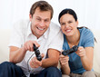 Joyful couple playing video games together on the sofa