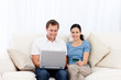 Happy couple buying online with laptop and credit card