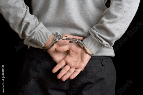 Photo: Man in handcuffs on black background Man in handcuffs on black background