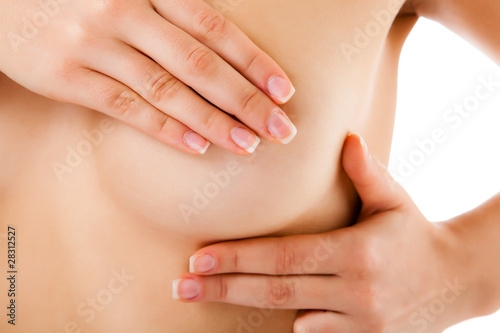 Photo: Woman examining her breast isolated on white Woman examining her breast isolated on white