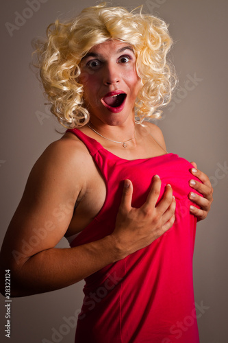 Photo: A man dressed as a woman holding his breasts A man dressed as a woman holding his breasts