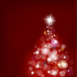 Christmas tree with blurred lights on red background.