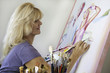 artist in her fifties painting on canvas