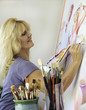 artist in her fifties painting on canvas