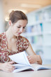 pretty young college student in a library (shallow DOF; color to