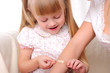 little girl puts a plaster