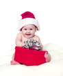 Smiling Baby Wearing Santa Hat and Playing with Red Gift Smiling Baby Wearing Santa Hat and Playing with Red Gift