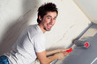 Smiling young man painting the wall