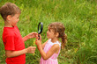little brother and sister play with big black loop in nature