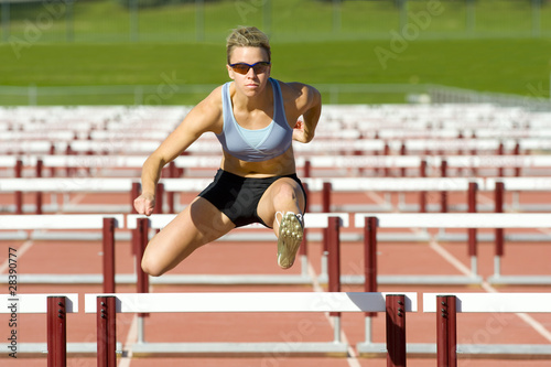 Photo: Athlete Jumping over Hurdles Athlete Jumping over Hurdles