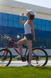 Wet brunette on the bicycle drink water Wet brunette on the bicycle drink water