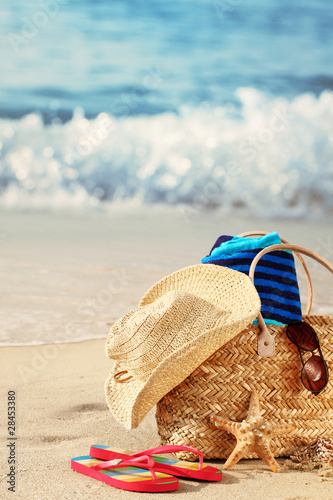 Photo: Summer beach bag on sandy beach Summer beach bag on sandy beach