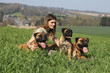 jeune femme et ses chiens bullmastiff assise dans l'herbe