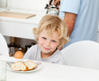 Little boy eating boiled egg and bread at breakfast Little boy eating boiled egg and bread at breakfast