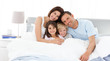 Happy children with their parents on the bed Happy children with their parents on the bed