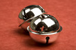 Two jingle bells isolated on red background