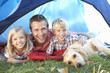 Photo: Young father poses with children in tent Young father poses with children in tent