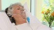 Woman lying on the bed with an oxygen mask