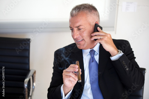 Foto: Businessman smoking a cigar Businessman smoking a cigar